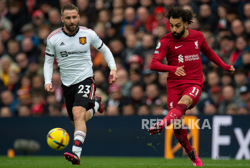 Pemain Manchester United Luke Shaw (kiri) beraksi dengan pemain Liverpool Mohamed Salah (kanan) selama pertandingan sepak bola Liga Primer Inggris antara Liverpool FC dan Manchester United di Liverpool, Inggris, (5/3/2023).