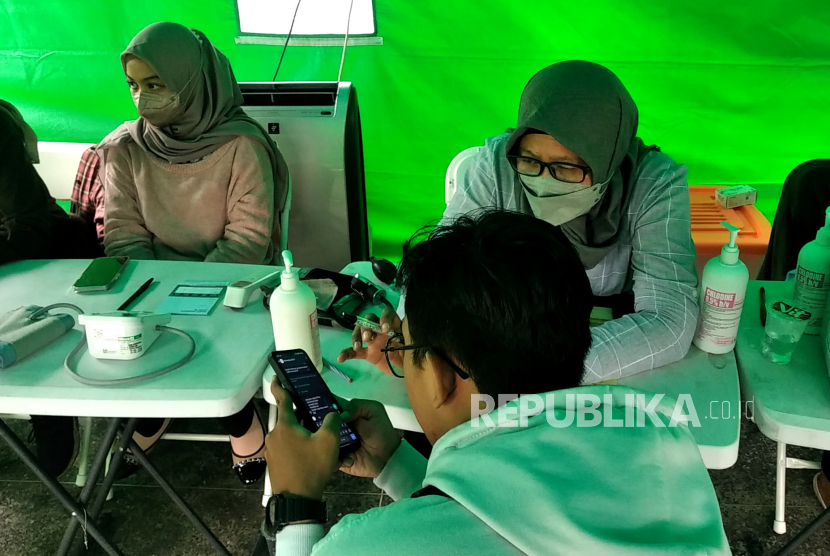 Wisatawan memanfaatkan layanan vaksinasi Covid-19 booster di Posko Kesehatan Tempat Khusus Parkir (TKP) Abu Bakar Ali, Yogyakarta, Selasa (27/12/2022). Posko Kesehatan Dinkes Kota Yogyakarta ini selain untuk pelayanan kesehatan darurat juga melayani vaksinasi Covid-19 wisatawan saat Libu Nataru 2022/2023. Setiap hari sebanyak 60 dosis vaksin Pfizer disiapkan untuk masyarakat. Tiga titik posko kesehatan di Tugu Pal Putih, TKP ABA, dan Titik Nol Yogyakarta disiapkan untuk layanan vaksinasi Covid-19 wisatawan.