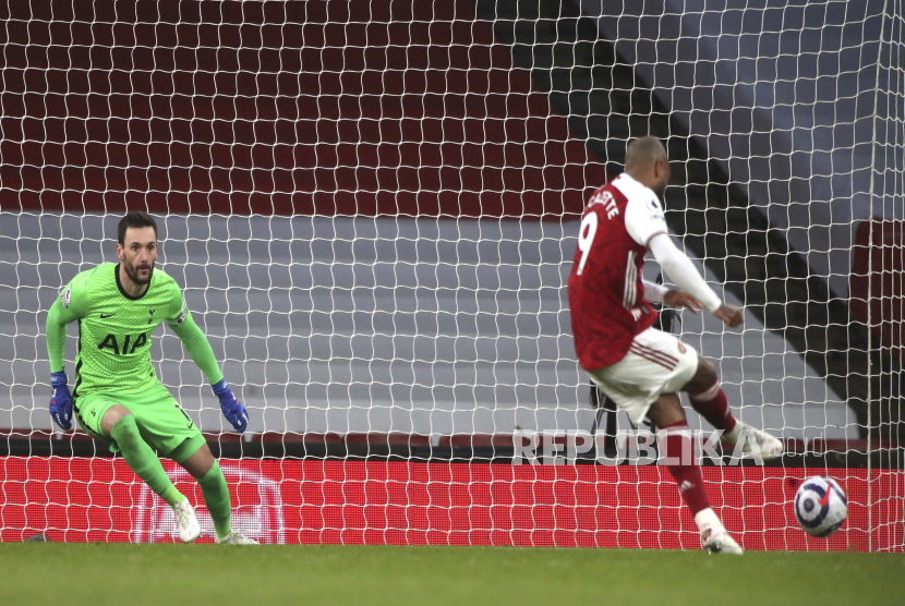 Alexandre Lacazette dari Arsenal melakukan tendangan penalti untuk mencetak gol selama pertandingan sepak bola Liga Premier Inggris antara Arsenal dan Tottenham Hotspur di Stadion Emirates di London, Inggris, Minggu, 14 Maret 2021. 