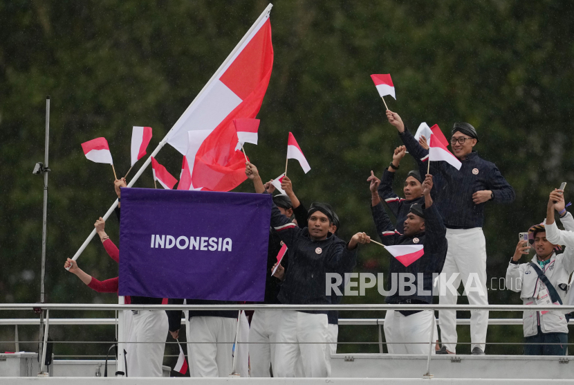 Kontingen Indonesia mengikuti defile dengan menaiki kapal menyusuri sungai Seine saat pembukaan Olimpiade Paris 2024 di Paris, Prancis, Jumat (26/7/2024). Sebanyak 205 kontingen dari negara peserta mengikuti defile pembukaan Olimpiade Paris 2024 dengan menggunakan 85 kapal menyusuri sungai Seine sejauh 6 km dari jembatan Austerlitz menuju Trocadero, dekat Menara Eiffel. 