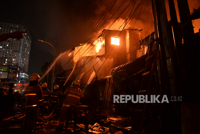 Petugas berusaha memadamkan kebakaran yang terjadi di Pasar Gembrong, Jakarta Timur, Ahad (25/4). Sedikitnya 14 mobil pemadam kebakaran diterjunkan untuk memadamkan api yang membakar sejumlah bangunan pertokoan dan rumah warga di Pasar Gembrong.
