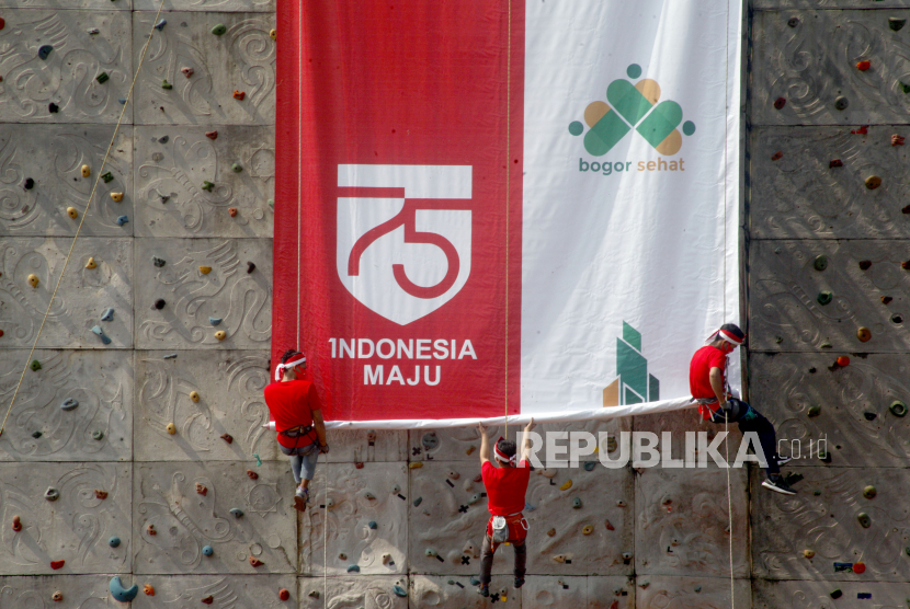Sejumlah atlet panjat tebing Jawa Barat memasang baliho di papan panjat tebing Lapangan Tegar Beriman, Cibinong, Kabupaten Bogor, Jawa Barat, Senin (3/8/2020). Pemasangan baliho berukuran 15 meter x 4 meter tersebut merupakan rangkaian acara Festival Merah Putih dalam menyambut HUT ke-75 Kemerdekaan RepubIik Indonesia. 