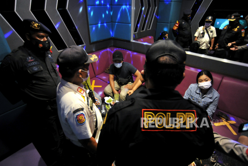 Petugas Satpol PP dan Polisi meminta pengunjung tempat karaoke yang melanggar aturan operasional untuk membubarkan diri saat sidak pelaksanaan PPKM (ilustrasi)