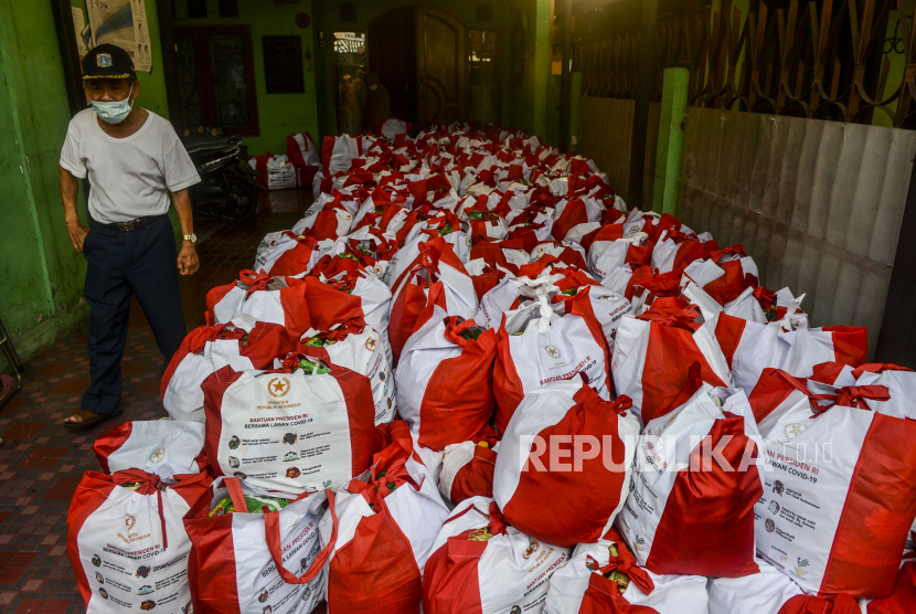 Warga melihat Bantuan Sosial (Bansos) Presiden saat distribusi di kawasan Kebon Jeruk, Jakarta, Ahad (3/5). Perum Bulog kembali menyalurkan bansos presiden tahap kedua.