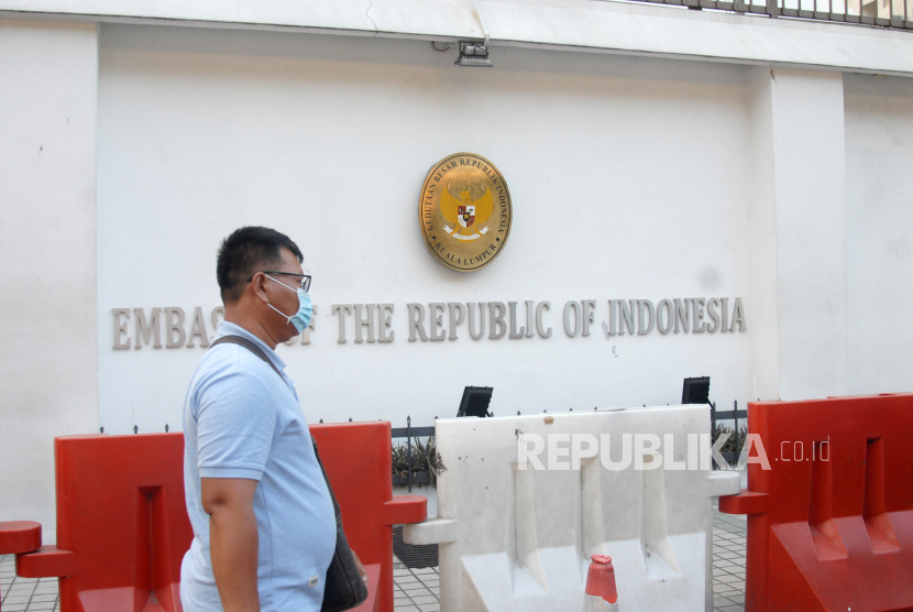 Seorang WNI berjalan di depan kantor Kedutaan Besar Republik Indonesia (KBRI) di Kuala Lumpur, Malaysia, Selasa (17/3/2020). Sejumlah layanan di KBRI KL terpaksa dihentikan untuk sementara waktu setelah Perdana Menteri Malaysia Muhyiddin Yassin mengumumkan bahwa pemerintah Malaysia memutuskan untuk melaksanakan 