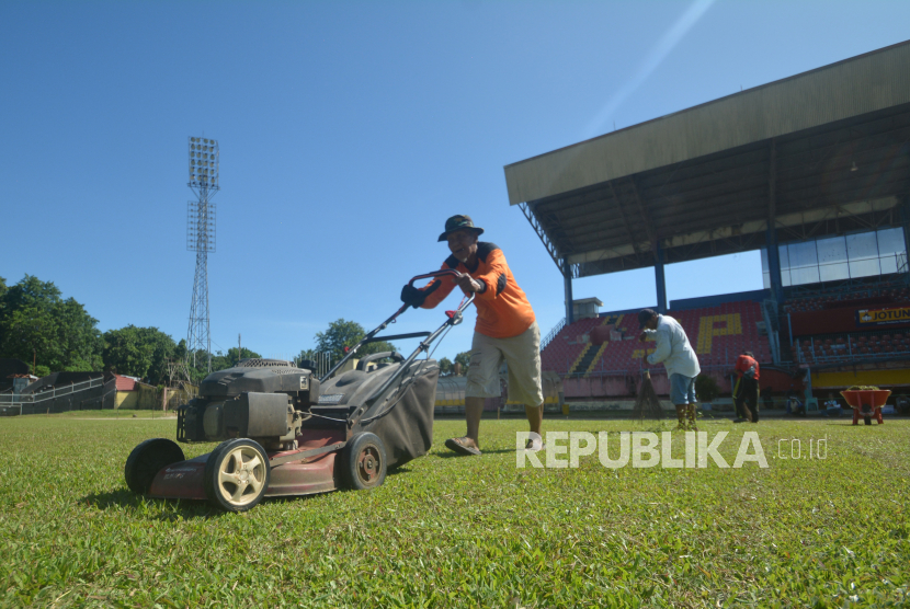 Pekerja merawat rumput di lapangan Stadion GOR H. Agus Salim, Kota Padang, Sumatera Barat, Senin (4/7/2022).