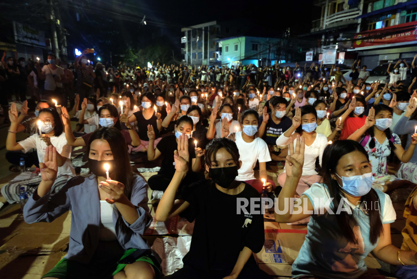  Pengunjuk rasa anti-kudeta memberikan penghormatan tiga jari selama unjuk rasa malam yang diterangi cahaya lilin di Yangon, Myanmar Minggu, 14 Maret 2021. Setidaknya empat orang ditembak mati selama protes di Myanmar pada hari Minggu, ketika pasukan keamanan melanjutkan tindakan keras mereka terhadap perbedaan pendapat menyusul kudeta militer bulan lalu.