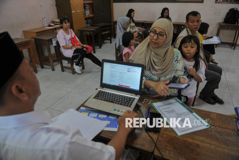Orang tua murid  melakukan proses pendaftaran Sistem Penerimaan Murid Baru (SPMB) 2025 di SDN Pejaten Barat 01, Jakarta, Senin (16/6/2025).