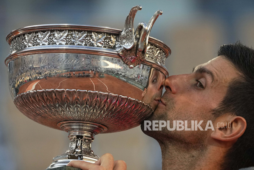Petenis Serbia Novak Djokovic mencium piala setelah mengalahkan Stefanos Tsitsipas dari Yunani dalam pertandingan terakhir turnamen tenis Prancis Terbuka di stadion Roland Garros, Minggu, 13 Juni 2021 di Paris.