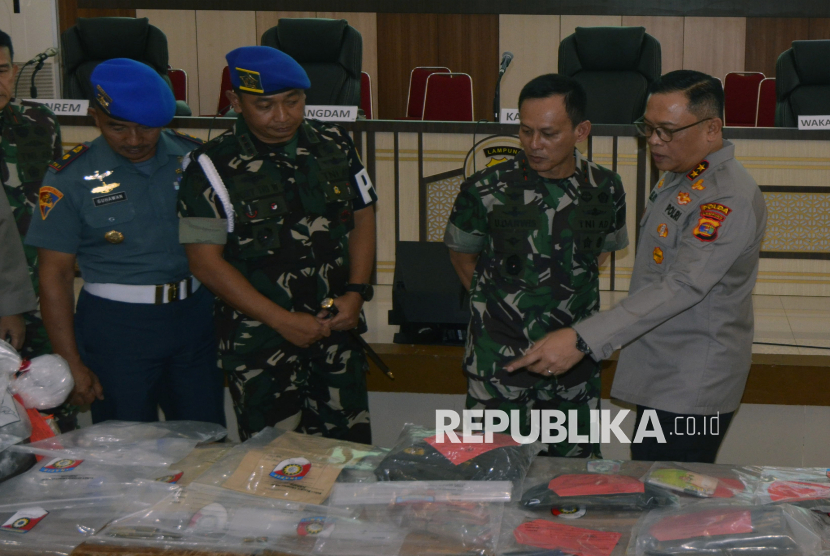 Kapolda Lampung Irjen Pol Helmy Santika (kanan) bersama Panglima Kodam II/Sriwijaya Mayjen Ujang Darwis (kedua kanan) melihat barang bukti yang berhasil diamankan dari tempat kejadian perkara (TKP) judi sabung ayam saat rilis di Polda Lampung, Lampung, Rabu (19/3/2025). Dalam keterangannya, Pangdam II/Sriwijaya Mayjen TNI Ujang Darwis mengatakan bahwa dua oknum TNI yang diduga terlibat dalam penembakan tiga anggota polisi di Kabupaten Way Kanan, Lampung, masih berstatus sebagai saksi. 