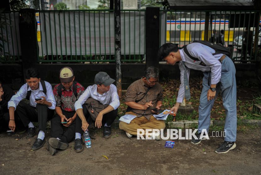 Pencari kerja mengisi form data diri untuk melamar kerja secara online saat menghadiri pameran bursa kerja Jakarta Jobfair di Gelanggang Olahraga Pulo Gadung, Jakarta Timur, Senin (19/5/2025). Pemprov DKI Jakarta kembali menggelar pameran bursa kerja di dua titik di wilayah Jakarta Timur yakni di GOR Ciracas dan GOR Pulo Gadung selama dua hari hingga Selasa (20/5) besok. Sebanyak 37 perusahaan berpartisipasi dalam pameran tersebut dengan harapan mampu menyerap tenaga kerja untuk mengurangi angka pengangguran di DKI Jakarta.