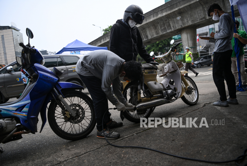 Petugas menguji emisi gas buang sepeda motor di pintu keluar Terminal Blok M, Jakarta Selatan. DLH DKI Jakarta melarang kendaraan pegawai yang belum uji emisi masuki area kantor.