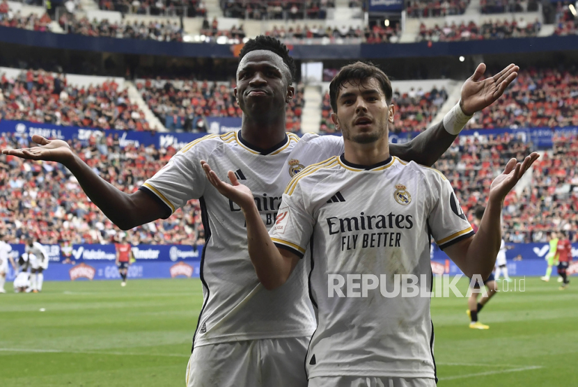 Brahim Diaz dari Real Madrid, kanan, merayakan bersama rekan setimnya Vinicius Junior dari Real Madrid setelah mencetak gol ketiga timnya dalam pertandingan sepak bola La Liga Spanyol antara Osasuna dan Real Madrid di stadion El Sadar di Pamplona, Spanyol, Sabtu (16/3/2024) malam.