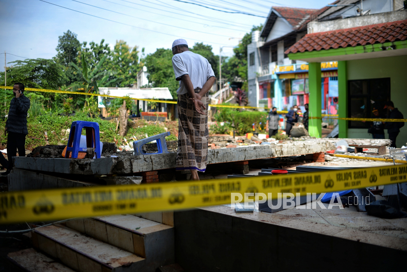 Warga memasuki garis polisi yang terpasang di lokasi peristiwa tembok roboh akibat banjir di MTsN 19, Pondok Labu, Jakarta Selatan, Jumat (7/10/2022). Menko PMK memastikan perbaikan MTsN 19 Jaksel tidak mengganggu pembelajaran.