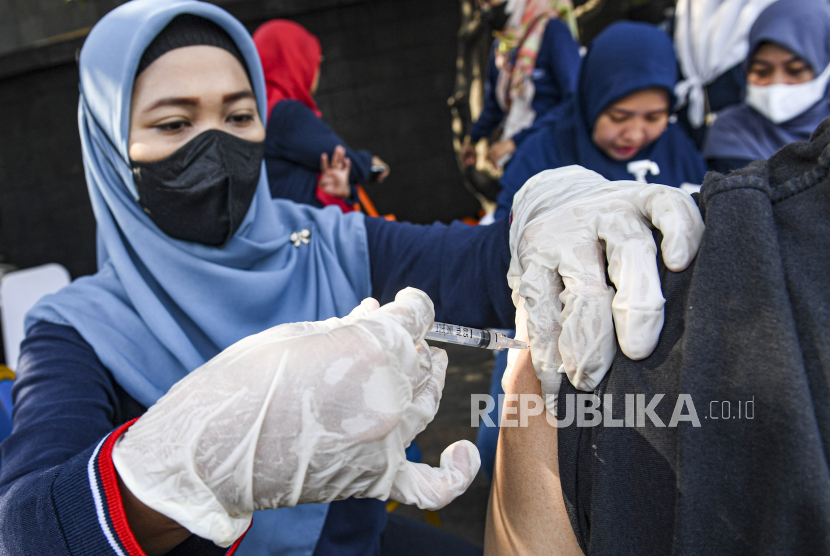 Petugas kesehatan menyuntikan vaksin COVID-19 di kawasan Bundaran HI, Jakarta, Ahad (17/12/2023).  Kementerian Kesehatan mengimbau masyarakat untuk segera melengkapi dosis vaksinasi COVID-19, sebagai upaya mengantisipasi lonjakan kasus saat libur Natal dan Tahun Baru 2024. 