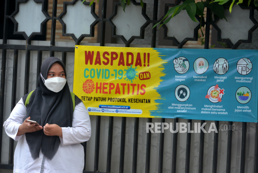 Spanduk imbauan waspada terhadap Covid-19 dan Hepatitis terpasang di depan Madrasah Muallimat, Yogyakarta, Jumat (20/5/2022). Guru Besar Fakultas Kedokteran Universitas Indonesia, Prof Tjandra Yoga Aditama menyambut baik pelonggaran penggunaan masker dalam ruangan terbuka dan pelonggaran kebijakan tes usap PCR atau Antigen bagi pelaku perjalanan. 