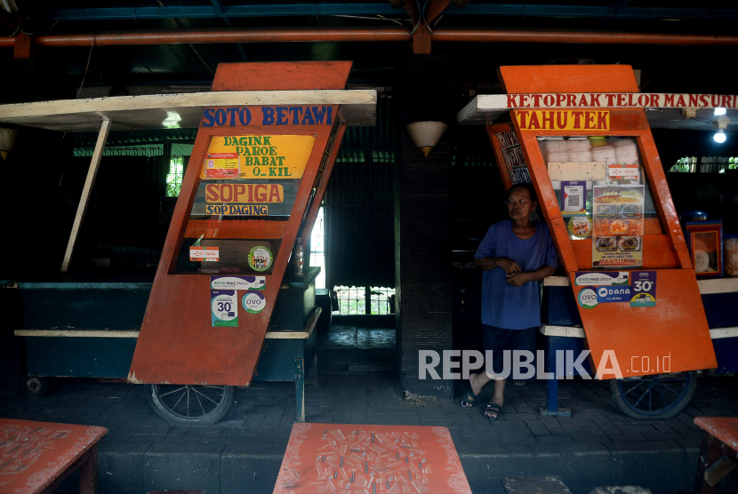 Pedagang makanan menanti pembeli di Pusat Jajanan Tenda Hijau, Karet, Jakarta, Kamis (2/4). Pembatasan aktivitas publik dan tutupnya sejumlah perkantoran dan pusat perbelanjaan di tengah pandemi Covid-19 berdampak langsung pada usaha kecil, seperti warung makan