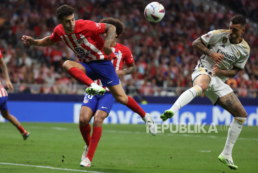 Pemain Atletico Madrid Mario Hermoso (Kiri) beraksi melawan Joselu (kanan) dari Real Madrid selama pertandingan sepak bola LaLiga Spanyol antara Atletico Madrid dan Real Madrid, di Madrid, Spanyol, Ahad (24/9/2023).