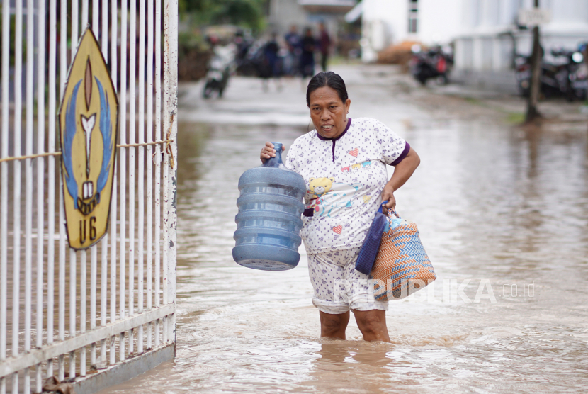 Warga berjalan melintasi banjir di Limboto, Kabupaten Gorontalo, Gorontalo, Jumat (1/10/2021). Ratusan rumah dan jalan utama di daerah itu diterjang banjir bandang setelah hujan deras mengguyur wilayah tersebut. 