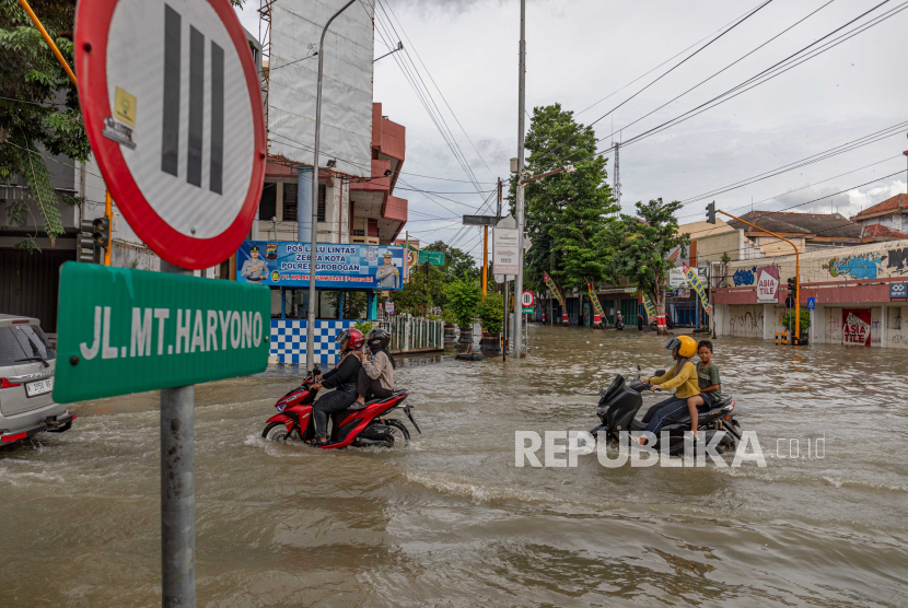 Pengendara sepeda motor melintasi genangan banjir di ruas Jalan MT Haryono, Kecamatan Purwodadi, Kabupaten Grobogan, Jawa Tengah, Rabu (7/2/2024). 