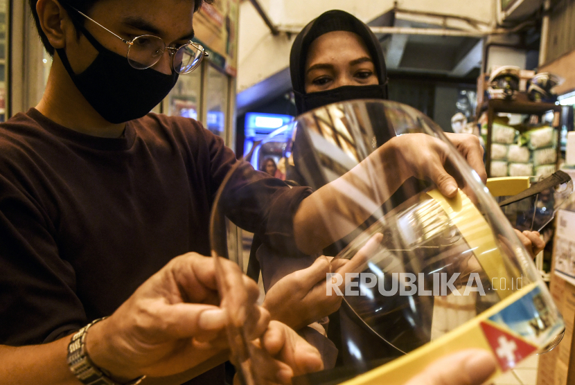 Calon pembeli memilih pelindung wajah (face shield) di Pasar Pramuka, Jakarta, Ahad (7/6/2020). 