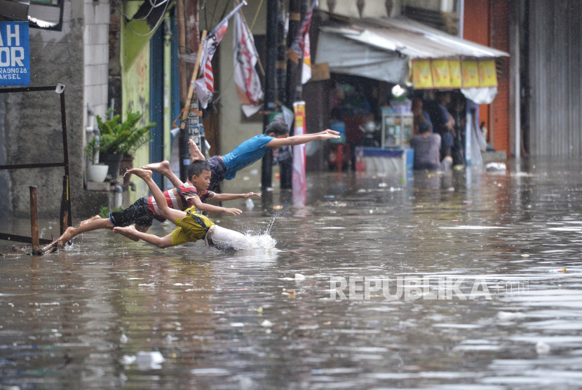 Anak-anak bermain saat banjir mengenangi Jalan Kemang Utara IX, Jakarta, Kamis (4/1/2024). Rumah pompa untuk kendalikan banjir di Kemang ditargetkan beroperasi pada Maret nanti.