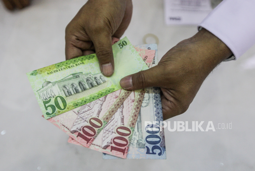 Petugas memperlihatkan mata uang riyal yang akan diberikan untuk calon jamaah haji. (Ilustrasi)