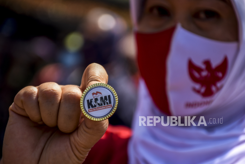 Seorang massa aksi menunjukkan pin Koalisi Aksi Menyelamatkan Indonesia (KAMI). (ilustrasi)