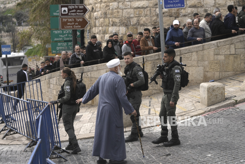 Petugas Polisi Perbatasan Israel berbicara dengan seorang jamaah lansia Palestina ketika yang lain mengantri di luar kompleks Masjid Al-Aqsa di Kota Tua Yerusalem menjelang shalat Jumat, Jumat, (23/2/2024).
