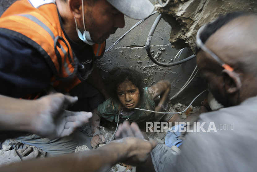 Warga Palestina mencoba menarik seorang gadis keluar dari reruntuhan bangunan yang hancur akibat serangan udara Israel di kamp pengungsi Jabaliya, Jalur Gaza utara, Rabu, 1 November 2023. 