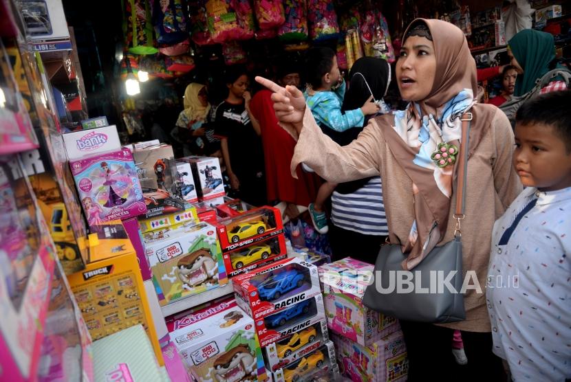 Calon pembeli memilih mainan untuk anaknya ketika berbelanja di Pasar Gembrong, Jakarta.