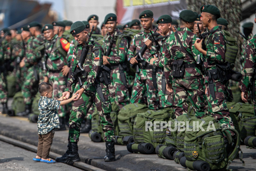 Prajurit Raider memegang tangan anaknya usai mengikuti upacara penyambutan Satgas Pengamanan Perbatasan Papua Nugini Yonif Raider 142/Ksatria Jaya di Pelabuhan Boom Baru Palembang, Sumatera Selatan, Minggu (21/5/2023). Sebanyak 400 prajurit Batalyon Infanteri (Yonif) 142/Ksatria Jaya Kodam II/Sriwijaya telah tiba di Palembang usai melaksanakan tugas pengamanan perbatasan RI-Papua Nugini selama 14 bulan. 