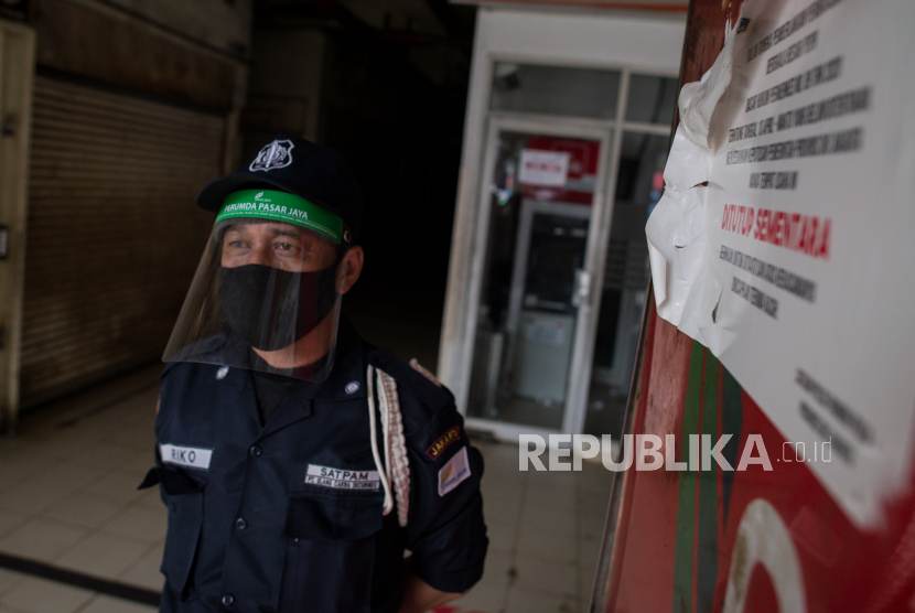 Petugas keamanan mengenakan pelindung wajah beraktivitas di kawasan Pasar Kebayoran Lama yang ditutup sementara di Jakarta, Kamis (18/6). Penutupan Pasar Kebayoran Lama dilakukan setelah 14 pedagang pasar dinyatakan positif COVID-19 usai mengikuti pemerikasaan uji swab terhadap 59 pedagang pasar beberapa hari lalu dan akan kembali dibuka pada 20 Juni 2020 mendatang setelah dilakukan sterilisasi