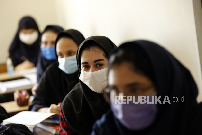 Gadis-gadis sekolah menengah Iran yang mengenakan masker wajah menghadiri kelas di sekolah swasta Bamdad Parsi pada hari pertama pembukaan kembali sekolah, di utara Teheran, Iran, 05 September 2020.