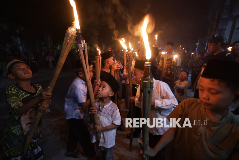 Anak-anak membawa obor saat takbir keliling.