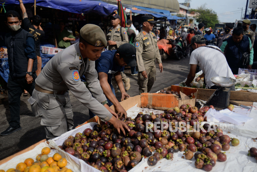 Personel Satuan Polisi Pamong Praja (Satpol PP) membantu pedagang kaki lima (PKL) mengangkut barang dagangannya saat dilakukan penertiban PKL di sekitar kawasan Pasar Kebon Kembang, Kota Bogor, Jawa Barat, Selasa (24/1/2023). 