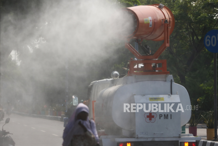 Petugas Palang Merah Indonesia (PMI) menyemprotkan larutan disinfektan di Jalan Kedung Cowek, Surabaya, Jawa Timur, Selasa (2/6/2020). Penyemprotan di sejumlah kawasan itu guna terus menekan penyebaran virus Corona (COVID-19) di Surabaya