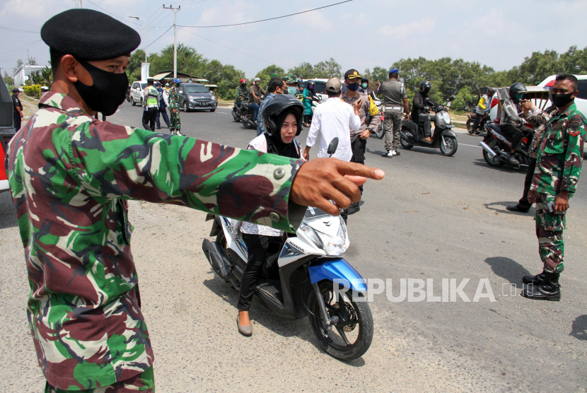Personel Polri dan TNI menghentikan warga tidak mengenakan masker saat razia penerapan wajib memakai masker (ilustrasi). 