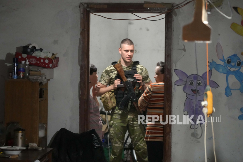 Seorang tentara Ukraina berbicara dengan wanita yang bersembunyi dari serangan Rusia di ruang bawah tanah di Lysychansk, wilayah Luhansk, Ukraina, Kamis, 16 Juni 2022.