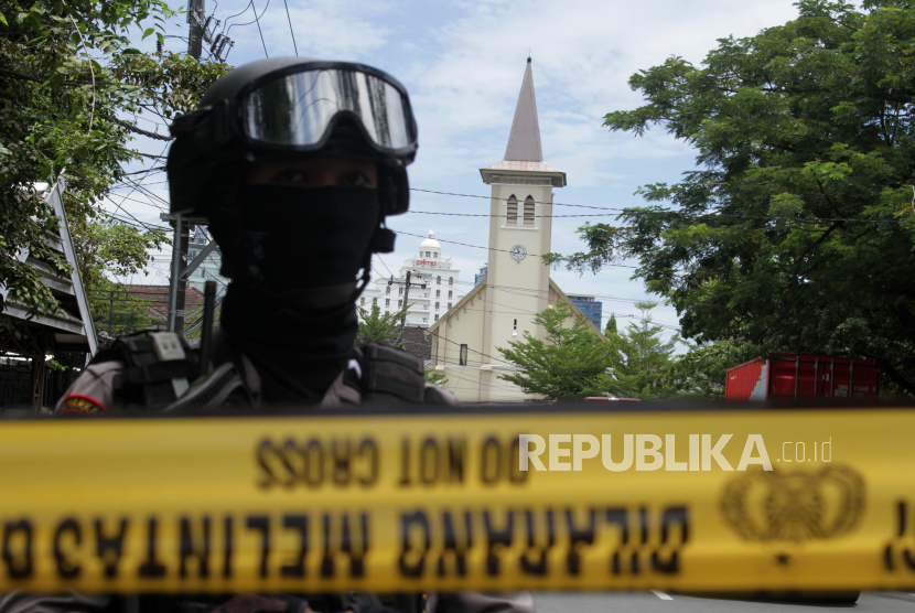 Anggota polisi berjada di ruas jalan menuju Gereja Katedral Makassar yang menjadi lokasi ledakan bom di Makassar, Sulawesi Selatan, Ahad (28/3/2021). Kapolda Sulawesi Selatan Irjen Pol Merdisyam mengatakan ledakan bom di gereja tersebut mengakibatkan satu korban tewas yang diduga pelaku bom bunuh diri serta melukai sembilan orang jemaat dan petugas gereja. 