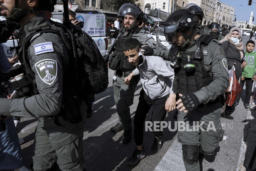 Petugas polisi perbatasan Israel menahan seorang pemuda Palestina di sebelah Gerbang Damaskus di luar Kota Tua Yerusalem, Senin, 28 Februari 2022. 