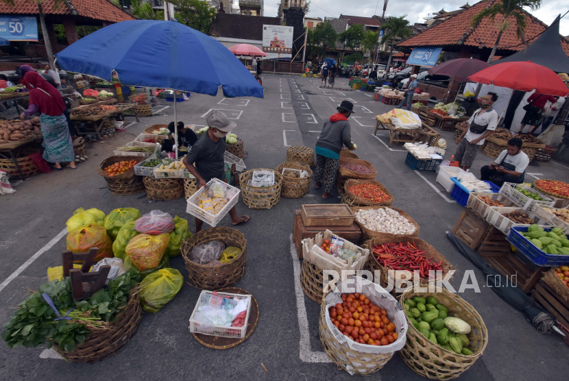 Sejumlah pedagang menyiapkan barang di lapak yang telah diatur jaraknya di area parkir Pasar Badung, Denpasar, Bali, Sabtu (9/5/2020). Presiden Joko Widodo berharap sektor perekonomian di Bali dapat segera bangkit seiring dengan program vaksinasi Covid-19 yang terus bergulir.
