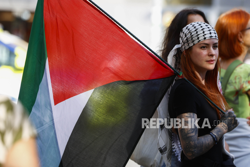  Demonstran mengenakan keffiyeh membawa bendera Palestina saat mengikut unjuk rasa pro-Palestina yang diadakan di Barcelona, ??Catalonia, Spanyol, Ahad (7/7/2024). 