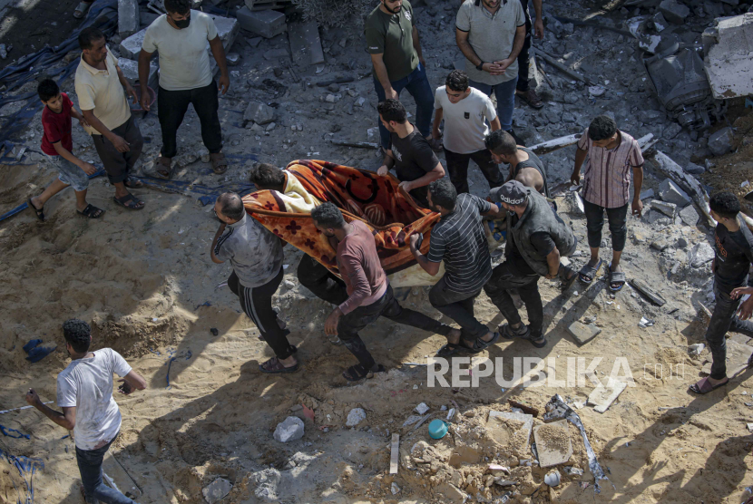 Palestinians carry the body of a deceased man following Israeli airstrikes on Al Falouja in Jabalia town, northern Gaza, 01 November 2023.