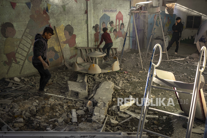 Warga Palestina melihat reruntuhan bangunan rumahnya yang hancur akibat serangan Israel di Rafah, Jalur Gaza.