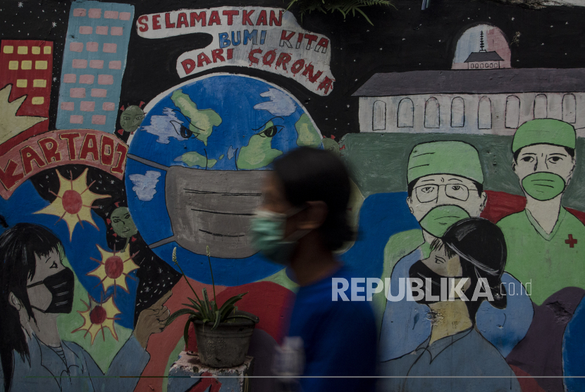 Warga melintasi mural  bertema Covid-19 di Bandung, Jawa Barat, Selasa (1/6/2021). Gubernur Jawa Barat Ridwan Kamil menyatakan Provinsi Jawa Barat siaga satu Covid-19 akibat melonjaknya kasus positif Covid-19 pascakebocoran arus mudik dan libur Lebaran 2021. 