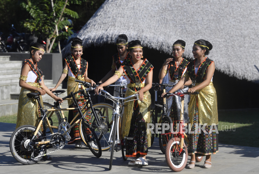 Beberapa remaja berpakaian khas Manggarai mendorong sepeda bambu di Labuan Bajo, Manggarai Barat, NTT, Sabtu (6/5/2023). Sepeda bambu tersebut rencananya dijadikan cenderamata bagi para kepala negara yang hadir pada KTT ASEAN ke-42 di Labuan Bajo.