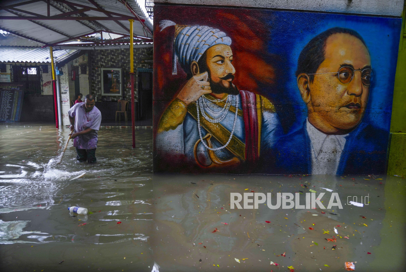 Pekerja membersihkan genangan air yang merendam area sekolah di Mumbai, India, Senin (8/7/2024). Banjir setinggi sekitar 40 centimeter disebabkan oleh intensitas hujan yang tinggi.