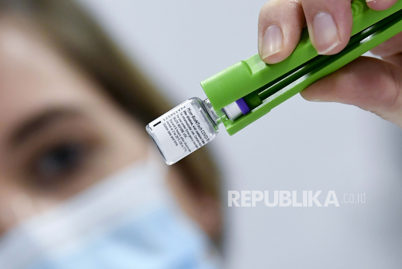 Seorang petugas kesehatan memeriksa botol vaksin Pfizer-BioNTech COVID-19 saat dicairkan di laboratorium di rumah sakit UZ Leuven di Leuven, Belgia, Minggu, 27 Desember 2020. 