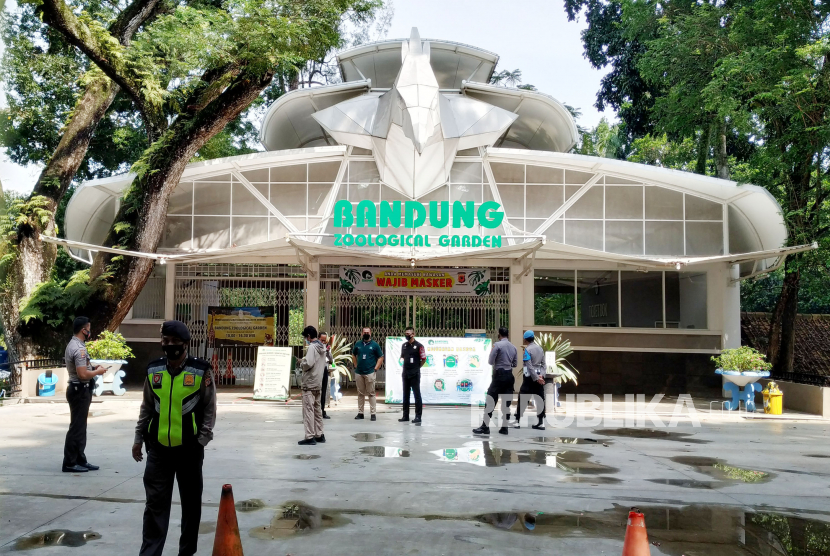 Petugas berjaga-jaga di depan Kebun Binatang Bandung. Pemerintah Kota Bandung telah memberikan pelonggaran kegiatan pada objek wisata seperti Kebun Binatang Bandung, Saung Angklung Udjo, Trans Studio Mal dan Kiara Artha Park. 